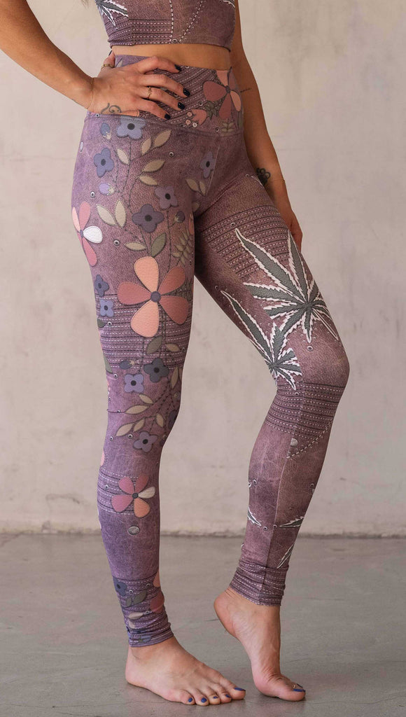 Model wearing WERKSHOP Dope + Flowers Mashup leggings. The leggings are printed with original artwork by Chriztina Marie. One leg features patchwork daisys over grainy mauve toned leather background. The other leg features marijuana leaves over a warm brown background. Both legs have faux stitching.