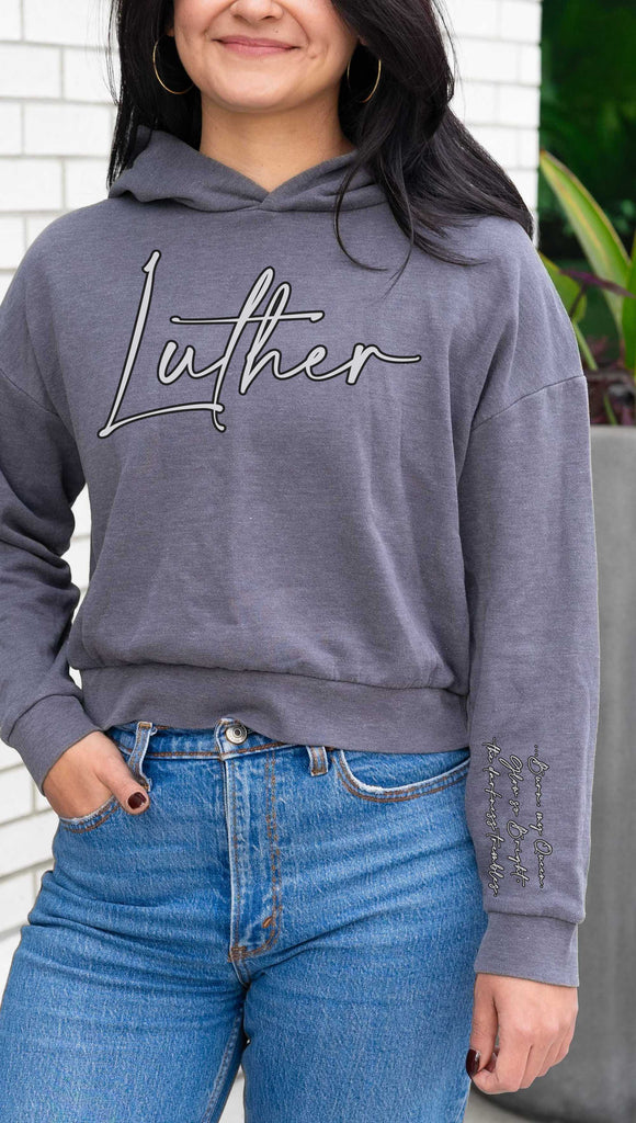 WERKSHOP  "Luther" Boyfriend Hoodie. Officially licensed from Spark of the Everflame by Penn Cole. The hoodie has "Luther" on the front chest
... and "Burn, my Queen. Glow so Bright, the darkness trembles" on the sleeve. Shown here in Gray with white writing.