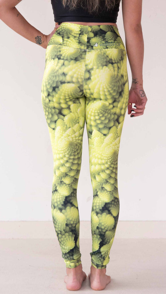 Model wearing WERKSHOP Romanesco Cauliflower Leggings. The fabric is printed with macro fractal details with bright green/yellow tones.