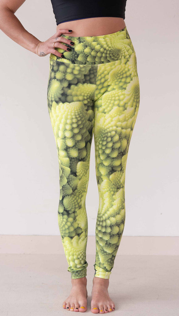 Model wearing WERKSHOP Romanesco Cauliflower Leggings. The fabric is printed with macro fractal details with bright green/yellow tones.