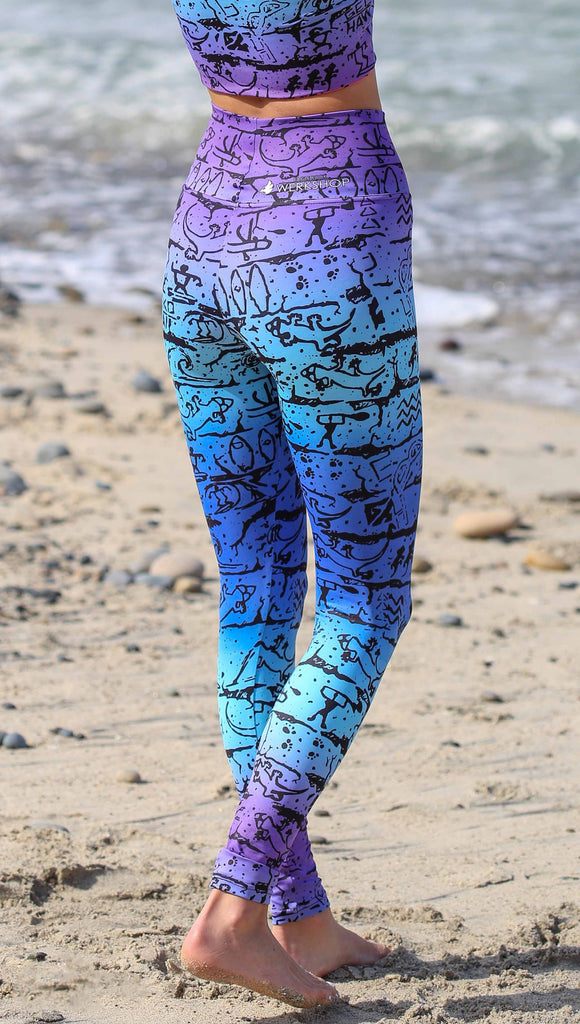 Gecko Hawaii X WERKSHOP "Surf" Collab. This photo shows a model wearing the leggings: featuring iconic Gecko Hawaii artwork in a blue/purple ombre background. 