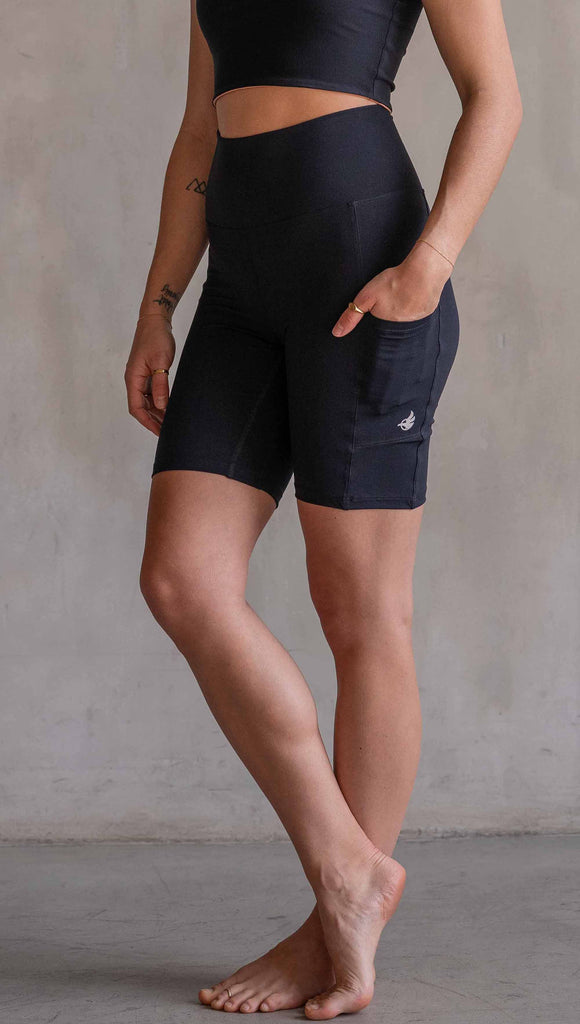 Model wearing WERKSHOP Black EnviSoft Bicycle Length Shorts with Pockets. Featuring flatlock seams and a small eagle logo on the wearer's left thigh.