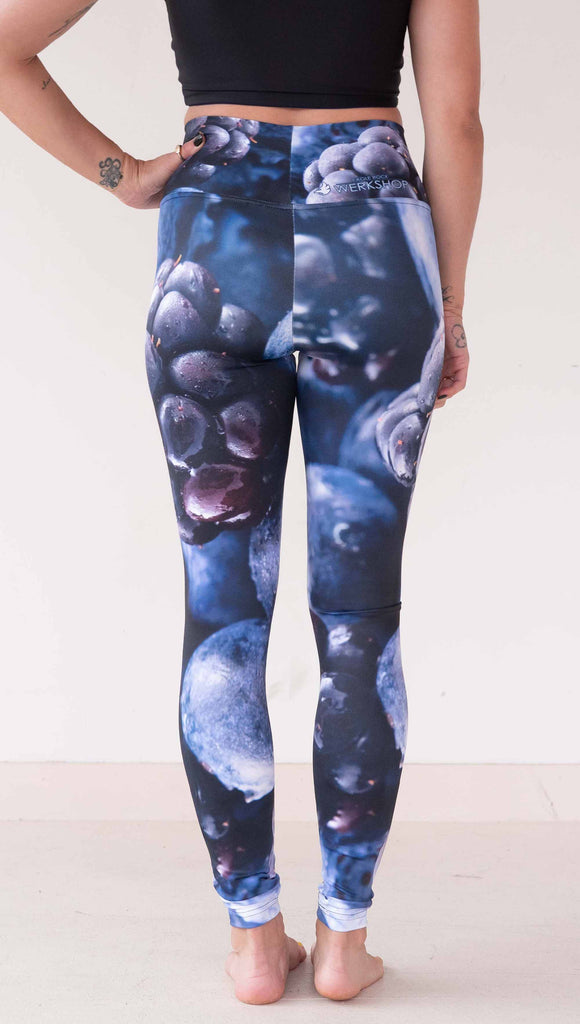 Model wearing WERKSHOP leggings printed with a macro images of blueberries and blackberries. The leggings are vibrant rich blues and deep dark purples.