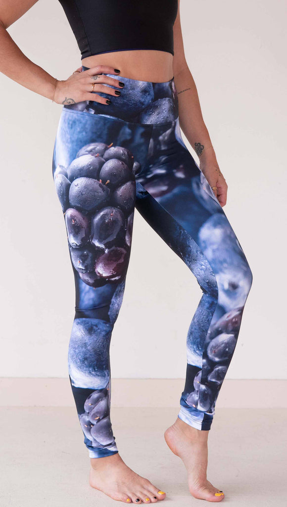 Model wearing WERKSHOP leggings printed with a macro images of blueberries and blackberries. The leggings are vibrant rich blues and deep dark purples.