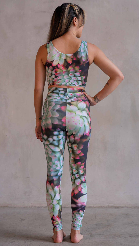 Model wearing WERKSHOP Mojave Sunset Athleisure Leggings. The print on the leggings features photo-real succulents with bright pops of green and hot pink.