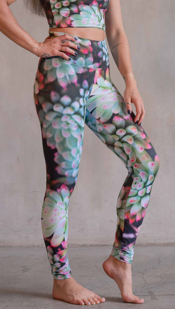 Model wearing WERKSHOP Mojave Sunset Athleisure Leggings. The print on the leggings features photo-real succulents with bright pops of green and hot pink.