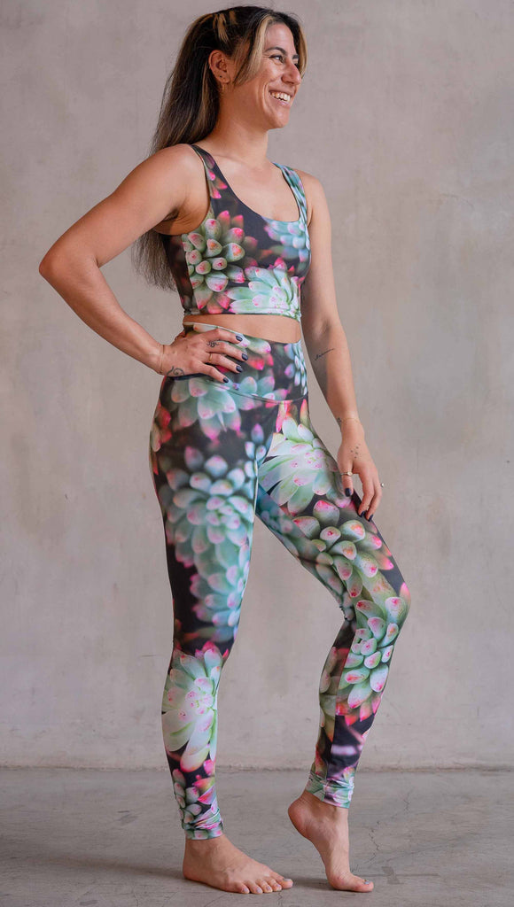 Model wearing WERKSHOP Mojave Sunset Athleisure Leggings. The print on the leggings features photo-real succulents with bright pops of green and hot pink.