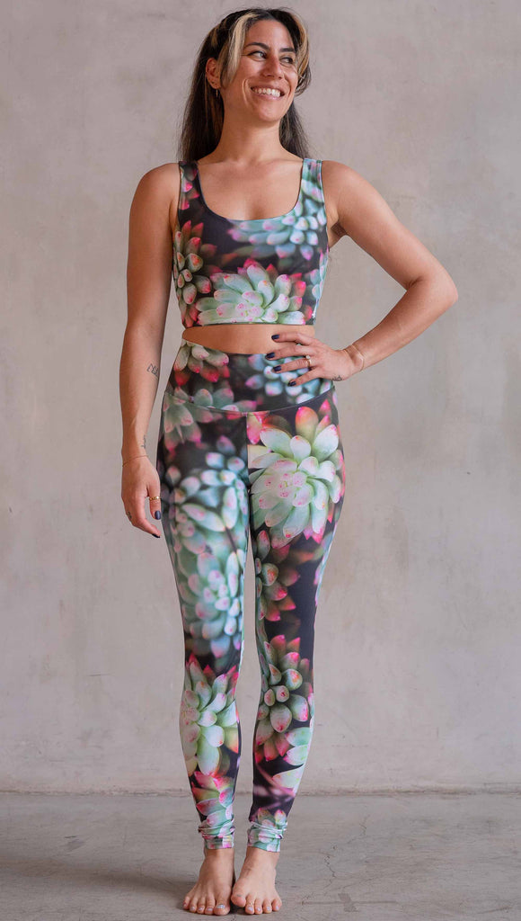 Model wearing WERKSHOP Mojave Sunset Athleisure Leggings. The print on the leggings features photo-real succulents with bright pops of green and hot pink.