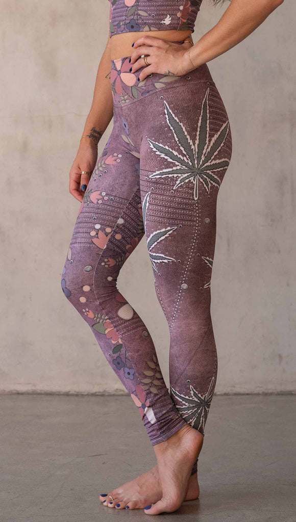 Model wearing WERKSHOP Dope + Flowers Mashup leggings. The leggings are printed with original artwork by Chriztina Marie. One leg features patchwork daisys over grainy mauve toned leather background. The other leg features marijuana leaves over a warm brown background. Both legs have faux stitching.