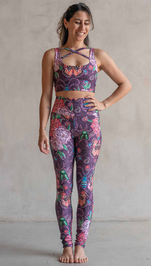 Full body front view of model wearing WERKSHOP Enchanted Garden EnviSoft Leggings with Pockets. The fabric is printed with original artwork by our Female Founder, Chriztina Marie. The artwork printed not the fabric features Butterflies, Beetles and Peonies over a warm fuchsia with bright bold pops of color on each beetle and Butterfly.