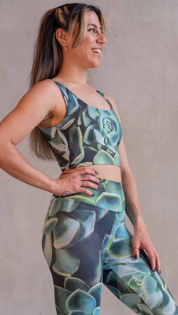 Model wearing WERKSHOP Mojave Sunset Reversible Top. One side is all green and the other side is green with bright pops of hot pink. Both sides are printed with photo-real succulents.