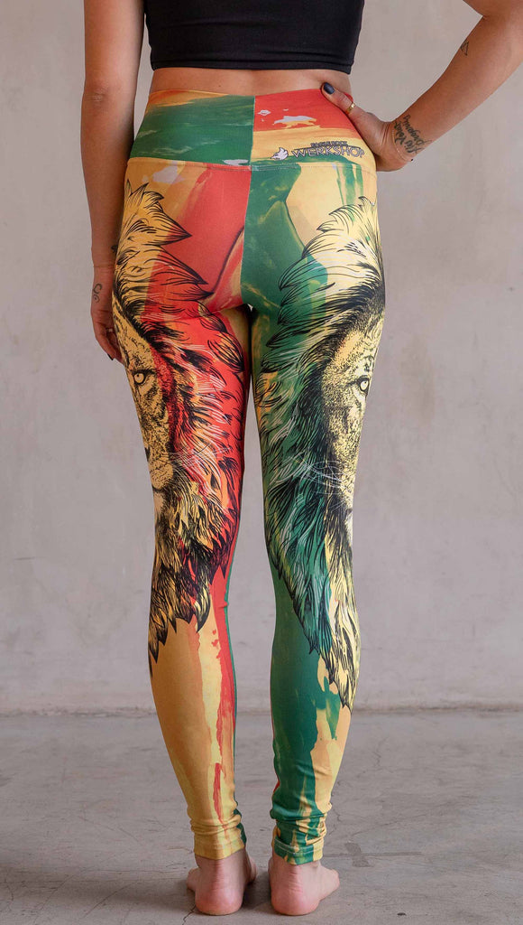 Model wearing WERKSHOP Lion of Zion Athleisure Leggings. The leggings feature a hand illustration of a lion over organic brustrokes in Rastafarian colors.