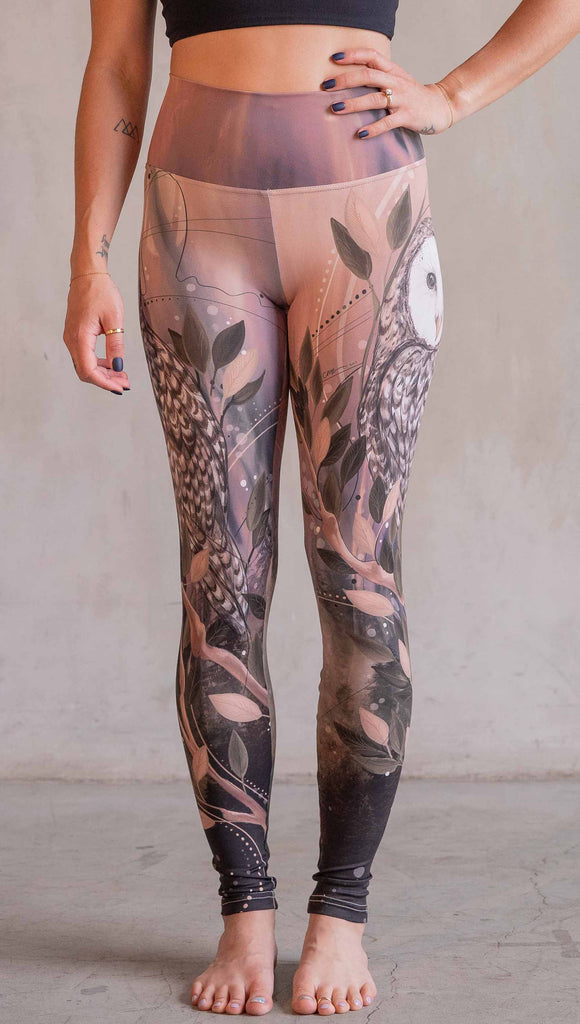 Model wearing WERKSHOP Owls Athleisure Leggings. The leggings are printed with a whimsical barn owl on the thigh surrounded by swirls and leaves on a mauve and cream toned background.