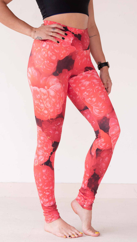 Model wearing WERKSHOP leggings printed with a macro image of bright bold red raspberries.