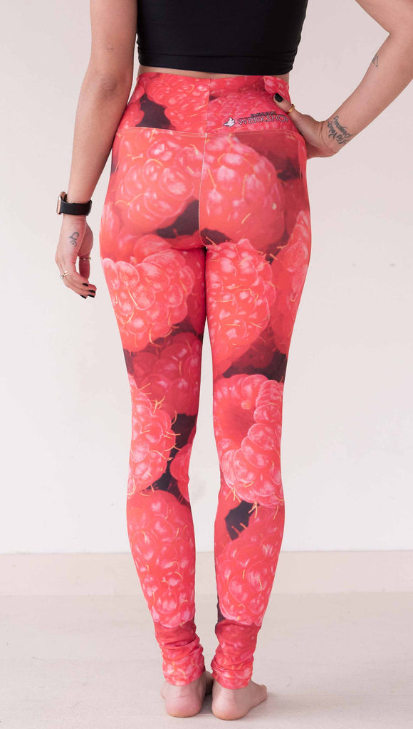 Model wearing WERKSHOP leggings printed with a macro image of bright bold red raspberries.