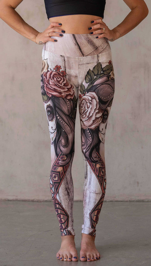 Girl wearing WERKSHOP "Remix" SugarSkull Athelisure leggings. The artwork printed on the leggings features a girl wearing Dia De Los Muertos makeup with a crown of roses and a beaded necklace with a romantic color woodgrain background.