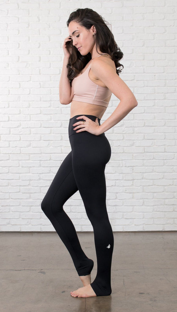 Left side view of model wearing black full-length leggings