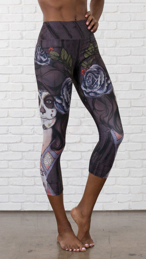 close up front view of model wearing sugar skull themed printed capri leggings