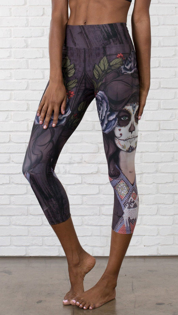 close up front view of model wearing sugar skull themed printed capri leggings