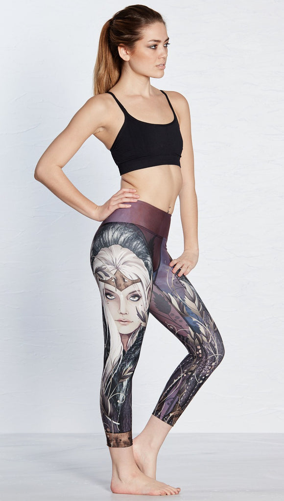 left side view of model wearing capri leggings with printed elf design