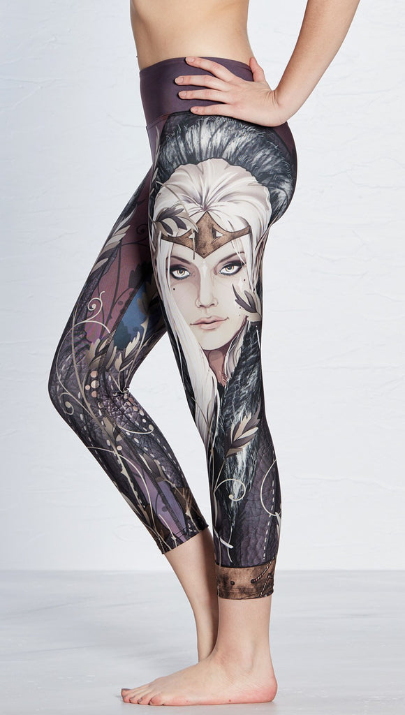 left side view of model wearing capri leggings with printed elf design