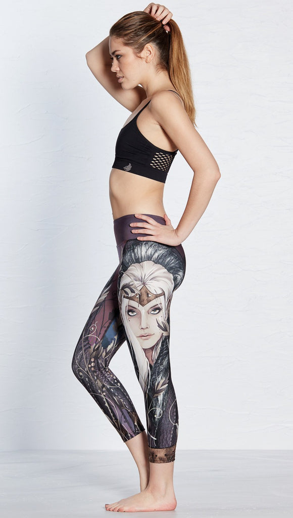 left side view of model wearing capri leggings with printed elf design