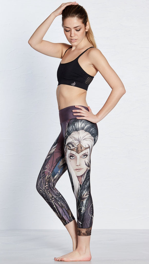 left side view of model wearing capri leggings with printed elf design