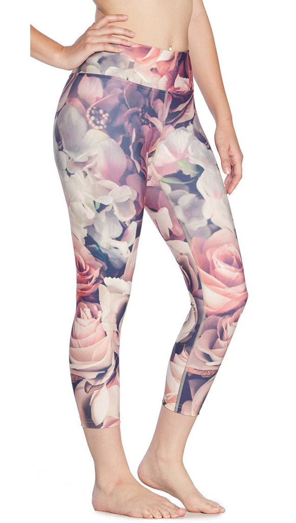 close up right side view of model wearing pink floral printed capri leggings