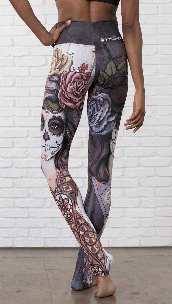 closeup back view of model wearing mashup Sugar Skull and Dia De Los Muertos themed printed full length leggings