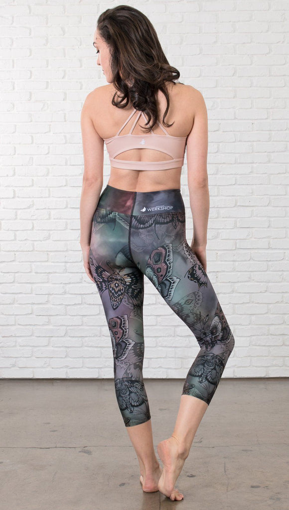 back view of model wearing capri printed leggings with gothic moths, gargoyles, skulls, ravens design