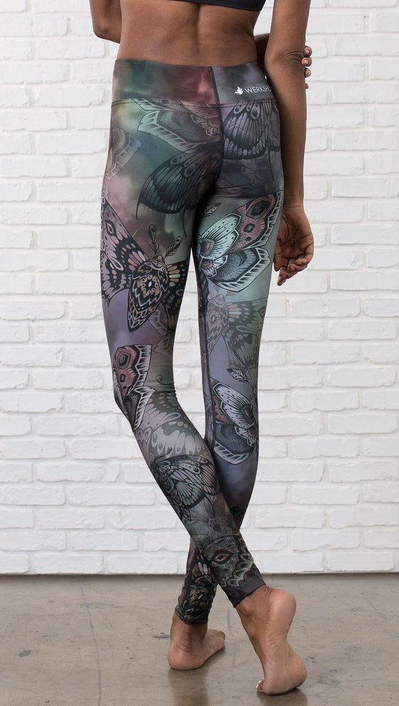 closeup back view of model wearing full length printed leggings with gothic moths, gargoyles, skulls, ravens design