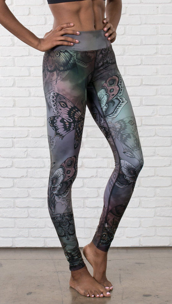 closeup front view of model wearing full length printed leggings with gothic moths, gargoyles, skulls, ravens design