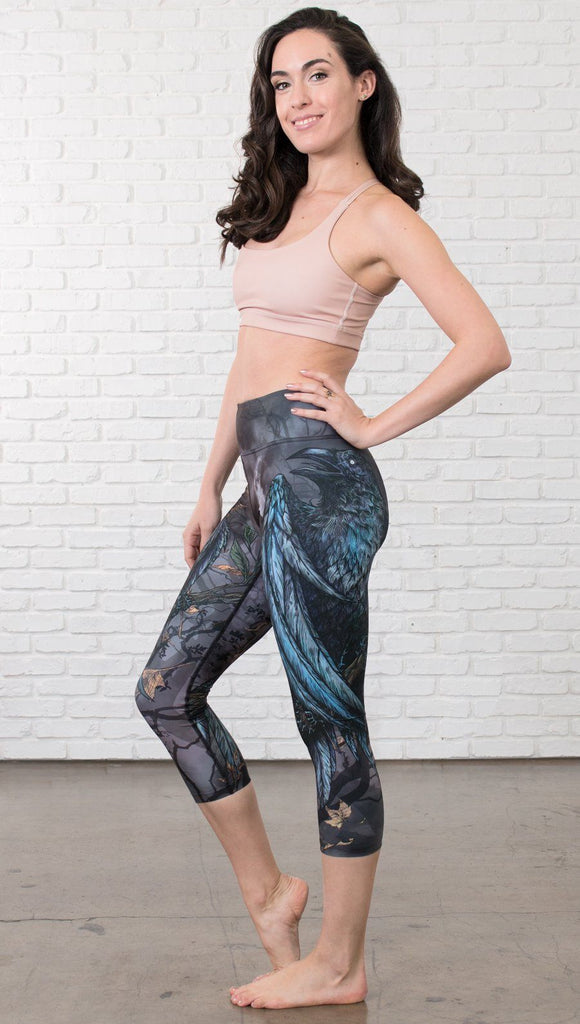 left side view of model wearing gothic themed printed capri leggings