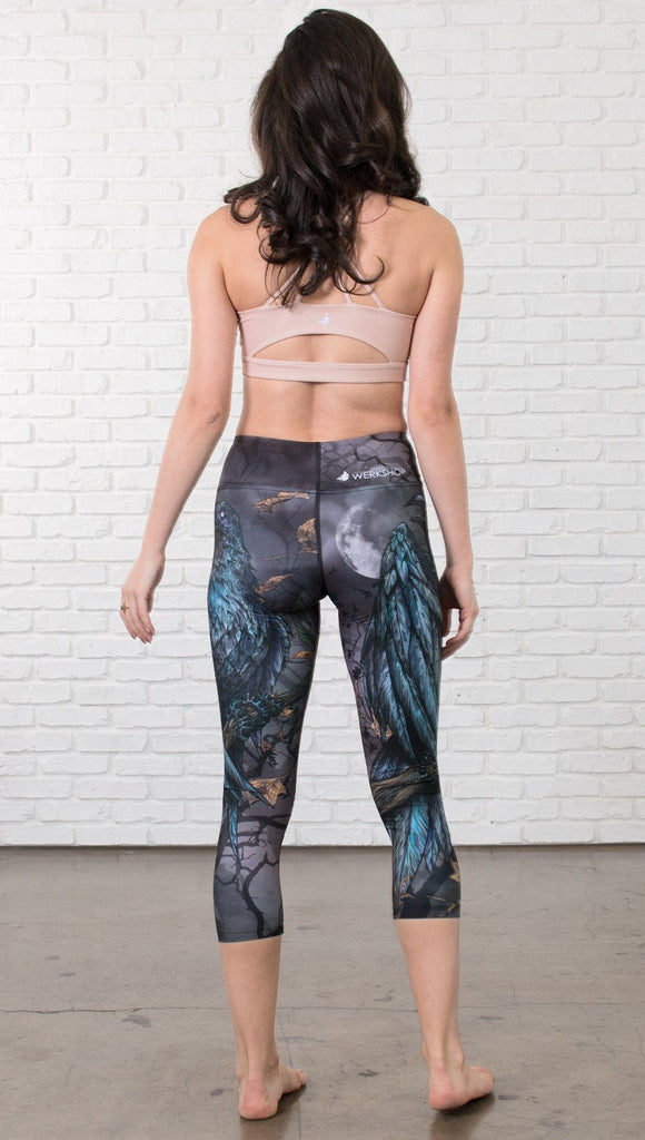 back view of model wearing gothic themed printed capri leggings