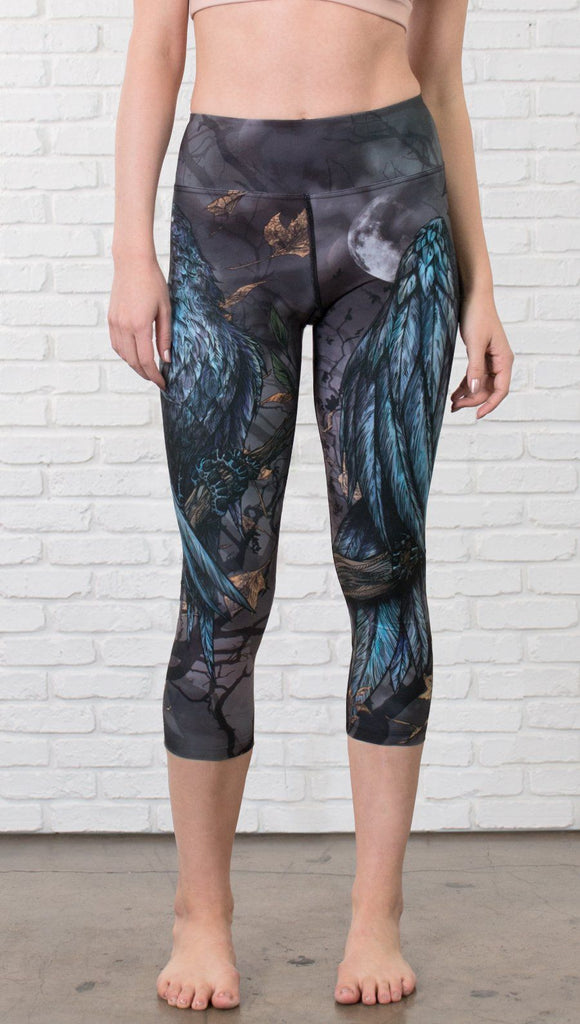 closeup front view of model wearing gothic themed printed capri leggings