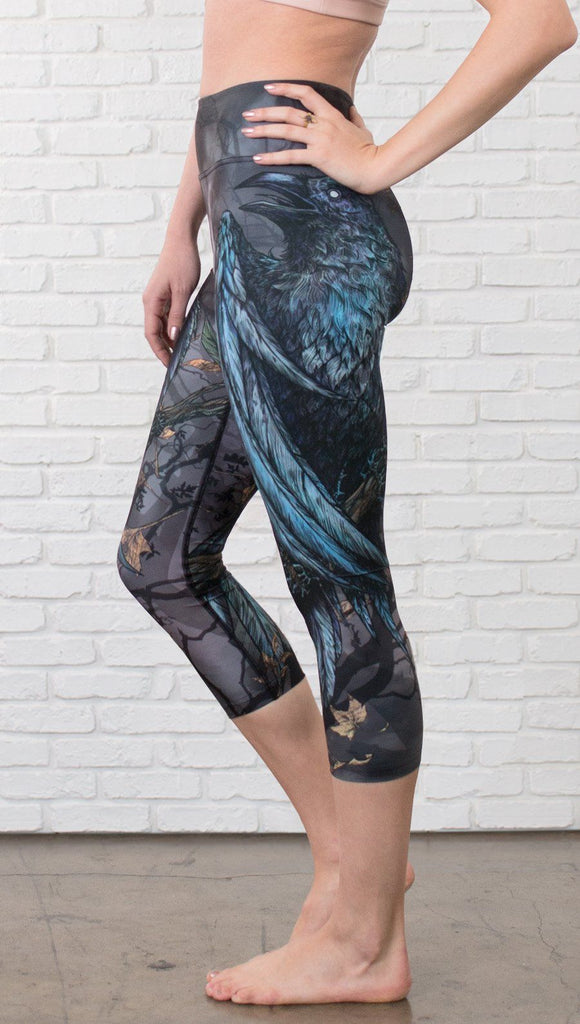 closeup left side view of model wearing gothic themed printed capri leggings