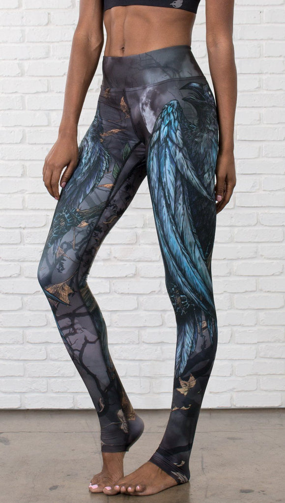 left side view of model wearing gothic themed printed full length leggings