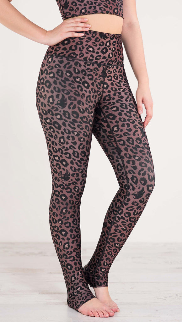 Right side view of model wearing the reversible red leopard print athleisure leggings in the colors dusty red and black