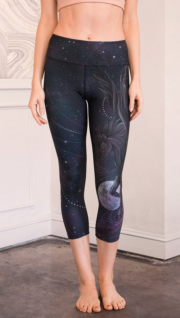 closeup front view of model wearing fantasy flying pegasus themed printed capri leggings