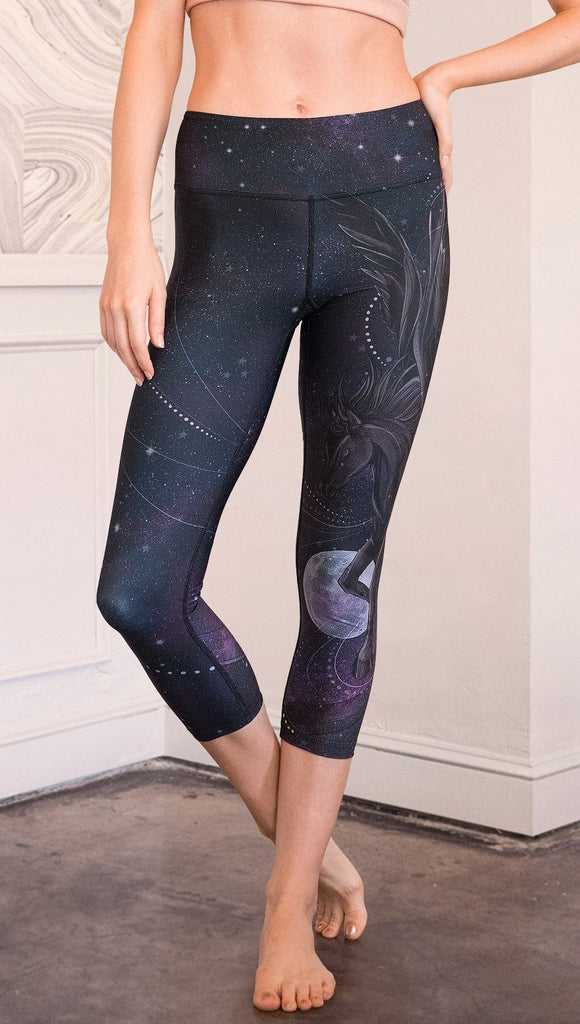 closeup front view of model wearing fantasy flying pegasus themed printed capri leggings