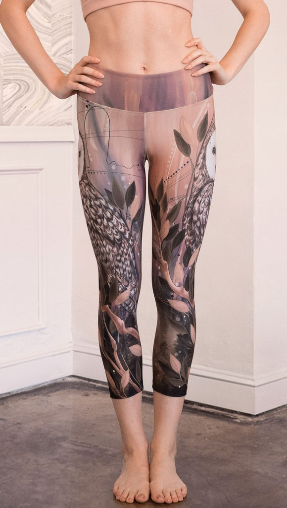 closeup front view of model wearing owl themed capri leggings