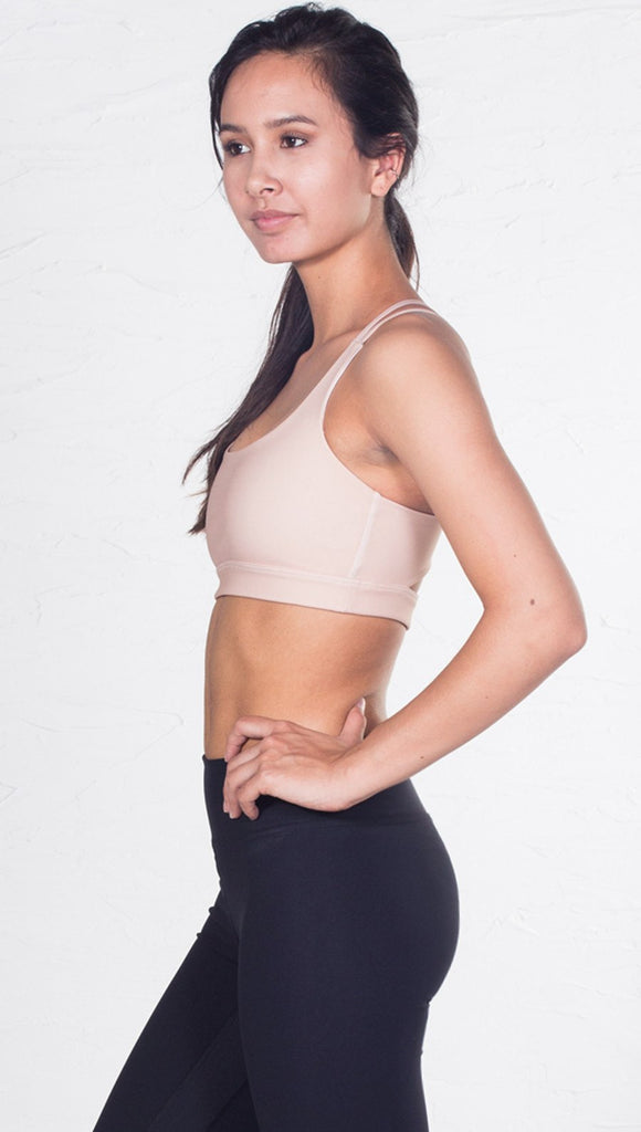 left side view of model wearing nude/beige sports bra