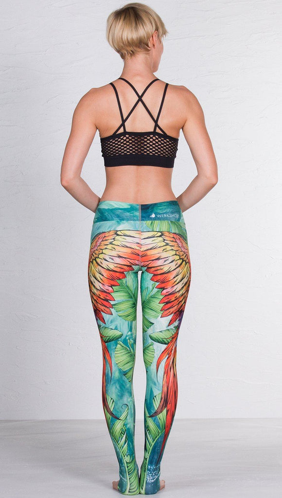 back view of model wearing macaw themed full length leggings