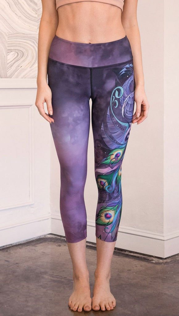 front view of model wearing peacock themed capri leggings