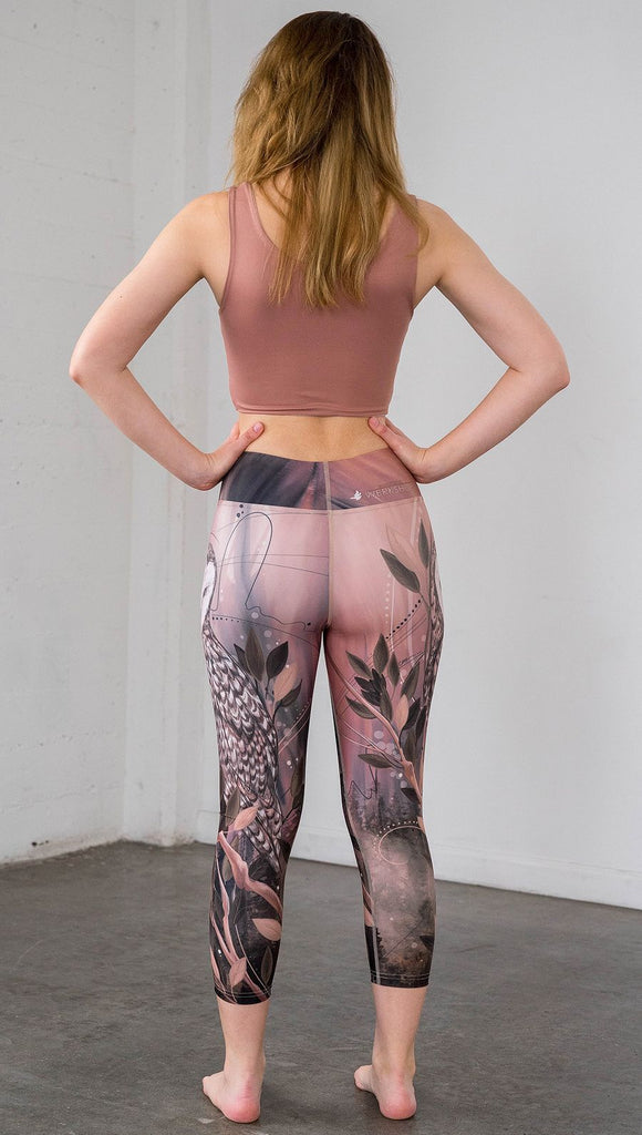 back view of model wearing owl themed capri leggings