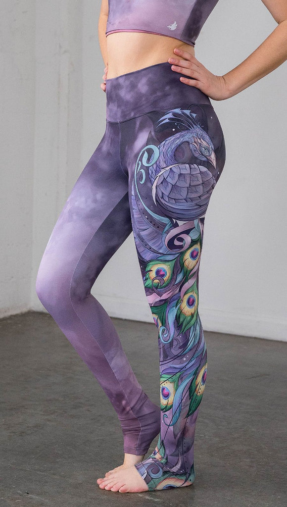 closeup left side view of model wearing peacock themed full length leggings