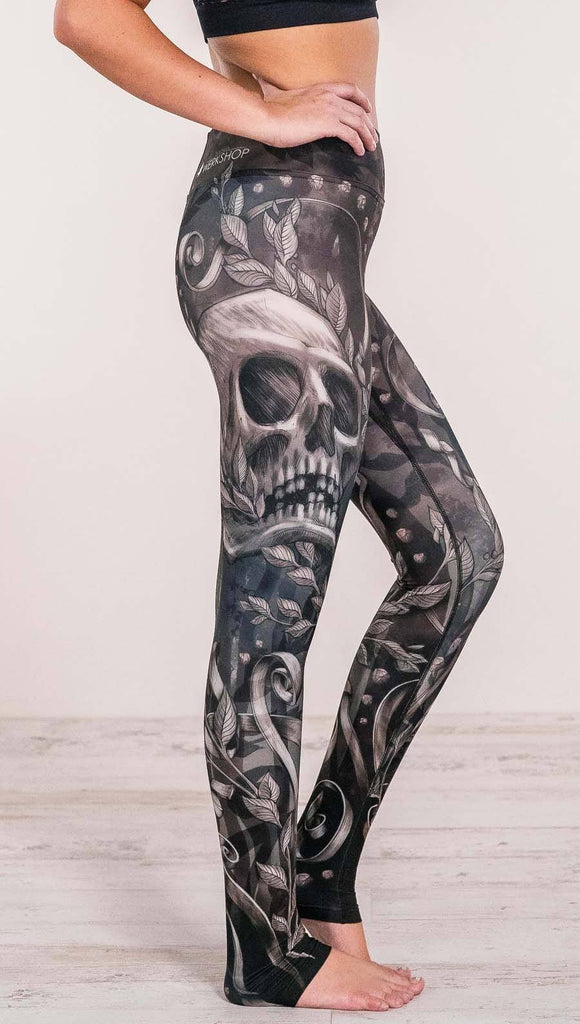 Close up right side view of model wearing gothic themed printed full length leggings