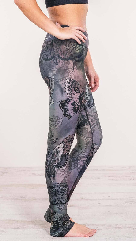 Close up right side view of model wearing full length printed leggings with gothic moths, gargoyles, skulls, ravens design