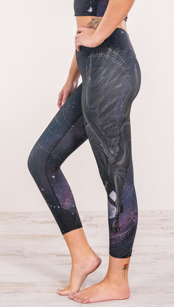 Close up side view of model wearing fantasy flying pegasus themed printed leggings