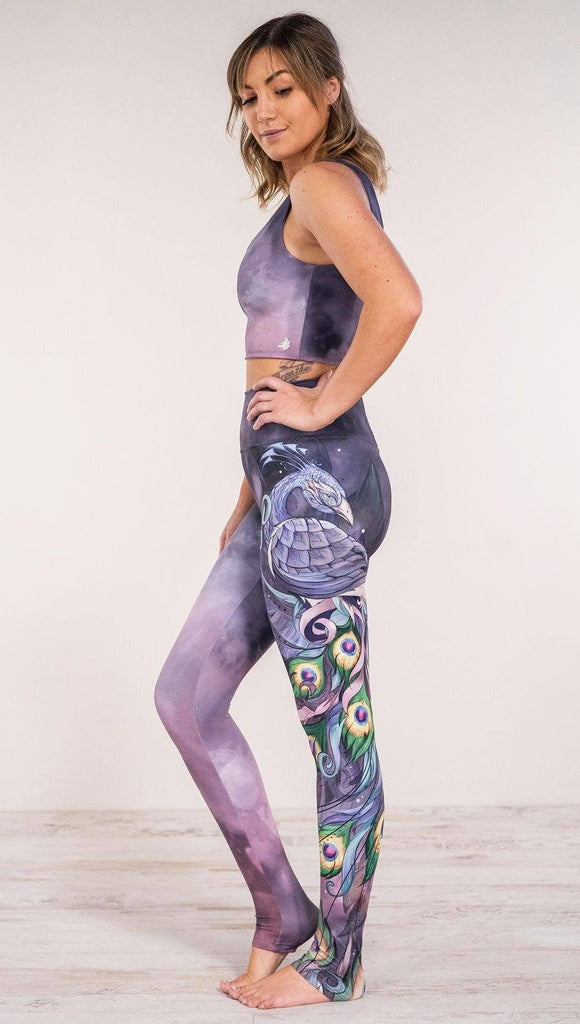 Side view of model wearing peacock themed full length leggings